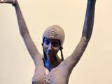 a statue of a woman that is standing in front of a clock