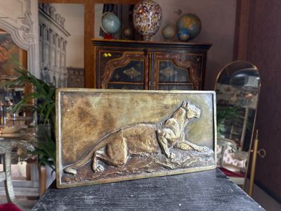a metal plaque with a dog on it on a table