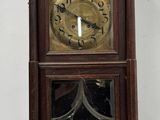 a wooden clock hanging on the wall in the room