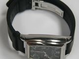 a watch that is on a black leather strap