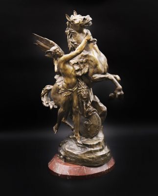 une statue en bronze représentant une femme à cheval tenant un oiseau