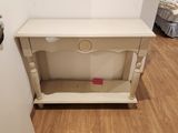 a small white table with a drawer on top of it