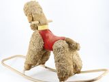 a teddy bear that is sitting on a wooden rocking horse