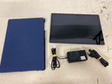 an image of a tablet computer sitting on top of a table next to a charger