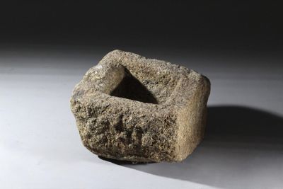 un objet en pierre posé sur une surface blanche