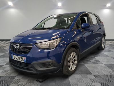 une Opel bleue garée dans une pièce au sol carrelé