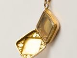 a small gold locke with a picture inside of it