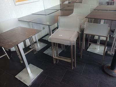 des tables et des tabourets dans un restaurant au sol carrelé de noir