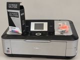 a canon printer sitting on top of a table next to a printer