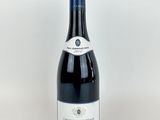 une bouteille de vin rouge posée sur une table blanche