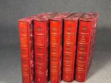 six red books are stacked on top of each other on a gray surface