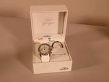 a white box with a watch inside of it on a table