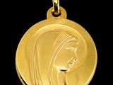 Gros plan sur une médaille d'or portant le visage d'une femme