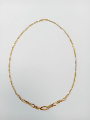 a gold necklace with a twisted link on a white background
