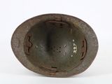 an old helmet with a hole in the middle of it on a white surface
