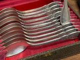 six silver spoons in a red case on a table