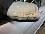 a white car with a measuring tape on it ' s side mirror