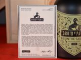 a bottle of alcohol sitting next to a card