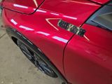 a close up of a red sports car parked in a garage