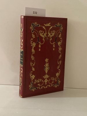 un livre rouge orné de motifs dorés, posé sur une table