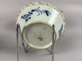 a blue and white cup on a stand on a table