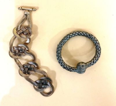 un bracelet en argent et une montre en argent posés sur une surface blanche