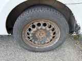 a dirty tire on the side of a white car