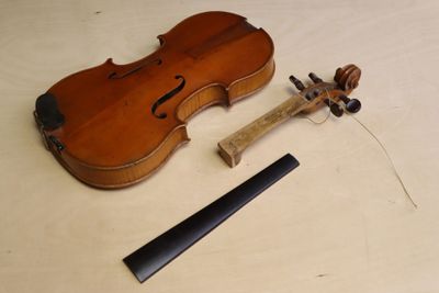 un violon posé sur une table à côté d'un morceau de bois