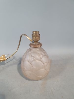une petite bouteille en verre avec une poignée dorée, posée sur une table