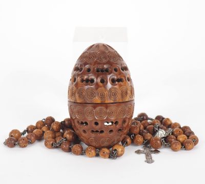 a close up of a wooden egg surrounded by beads