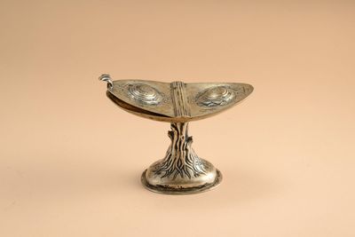 a silver plate with a bird on top of it