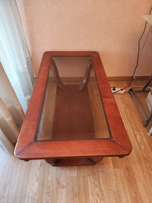 une table en bois avec un plateau en verre, posée sur un parquet en bois massif