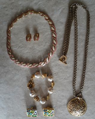 un collier, un bracelet et des boucles d'oreilles posés sur une table