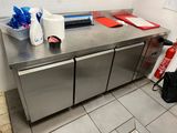 plan de travail en acier inoxydable dans une cuisine professionnelle, avec un extincteur