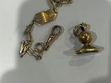 two pieces of jewelry sitting on a white surface