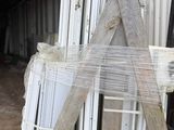 a pile of windows sitting on top of a pallet in front of a building
