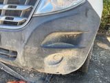 a close up of a car ' s front bumper with a broken tire