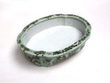 a green bowl with flowers on it sitting on a table
