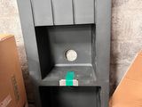 a gray shelf with a clock on it next to a cardboard box