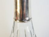 une poivrière en argent posée sur une table en verre