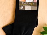 black knee high socks on a table with a plant in the background