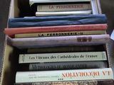 une boîte remplie de livres posée sur une table à côté d'une tasse
