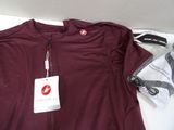 a red shirt with a tag on it next to a pair of shoes