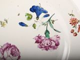 a plate with flowers painted on it on a table