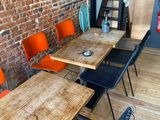 des tables et des chaises dans une pièce avec un mur en briques et un escalier