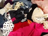 a pile of clothes that is sitting on top of a bed