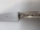 a close up of a knife on a table with a white background