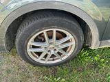 a car that is parked in the grass with the tire missing