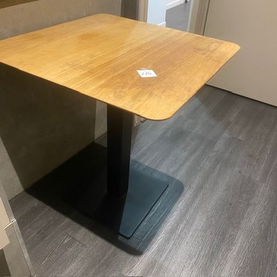 une table en bois avec un piètement noir dans une pièce