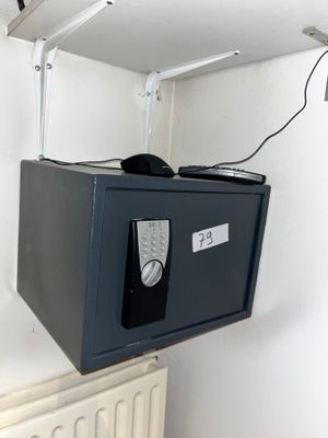 un petit coffre-fort fixé au mur au-dessus d'un radiateur